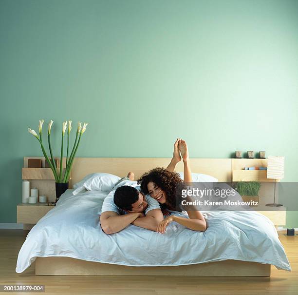 young couple lying on bed together - par säng bildbanksfoton och bilder