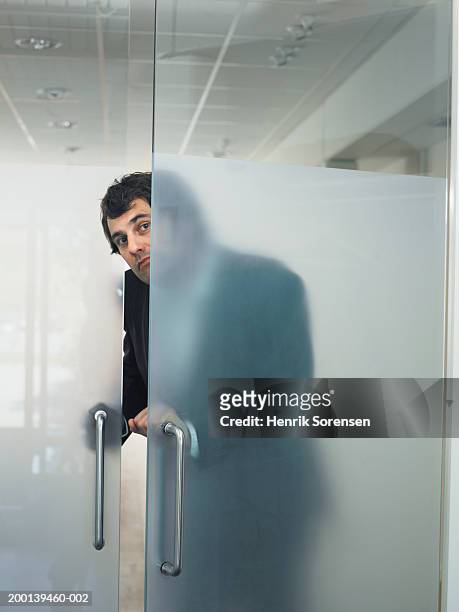 man opening transparent door from behind - office door open stockfoto's en -beelden