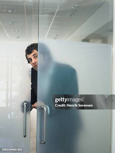 man opening transparent door from behind - office doorway stock pictures, royalty-free photos & images