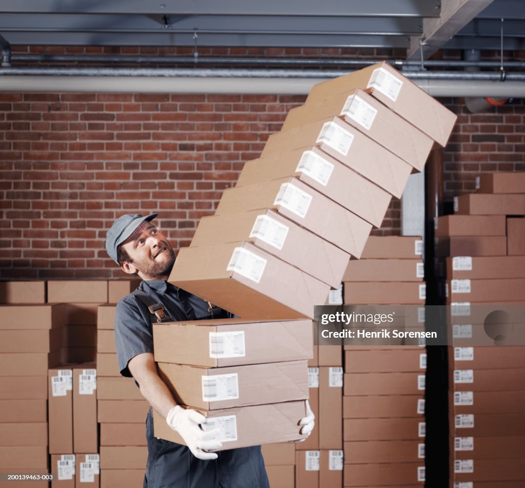 Falling Box On Racking Man Carrying Pile Of Falling Boxes In Storage Room High-Res Stock Photo ...