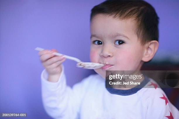 boy (2-4) eating, holding spoon to mouth, close-up - silver spoon in mouth stock pictures, royalty-free photos & images