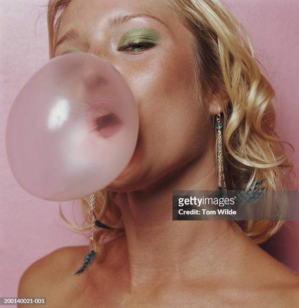 young woman blowing bubble gum, portrait, close-up - pink eyeshadow stock-fotos und bilder