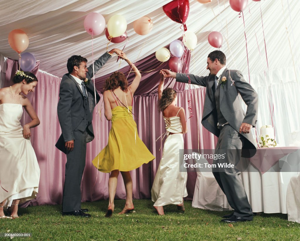 Bridal party dancing in marquee