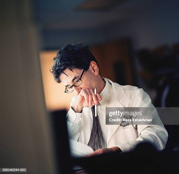 radiologist reading note, holding hand to mouth - doctor reading stock pictures, royalty-free photos & images