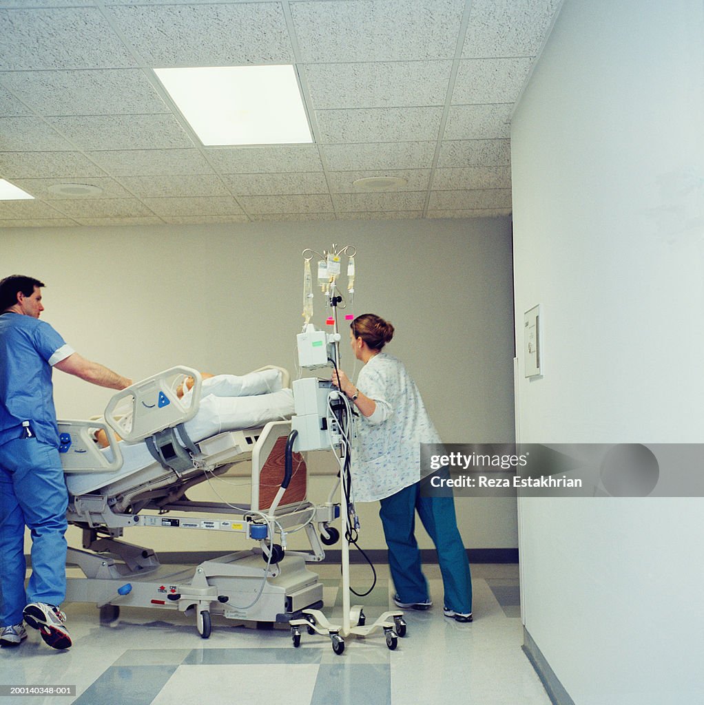 Patient with IV lying on hospital bed, being wheeled through hospital