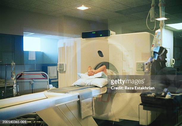 patient getting cat scan, clasping hands over head - cat scan machine stock pictures, royalty-free photos & images