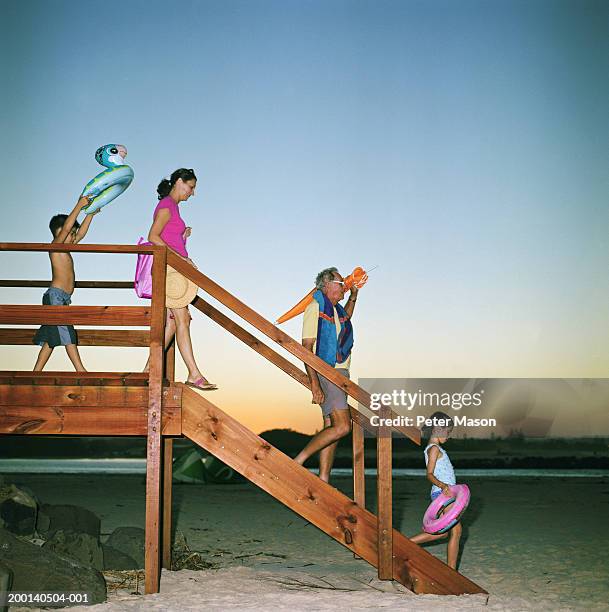 senior man, woman, girl and boy (6-8) descending steps to beach - step sibling stock pictures, royalty-free photos & images