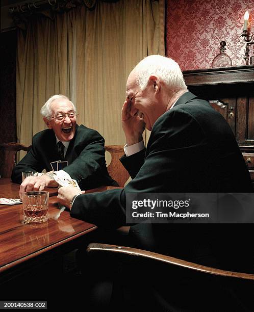 two senior men playing cards at table, laughing - senior men playing cards stock pictures, royalty-free photos & images