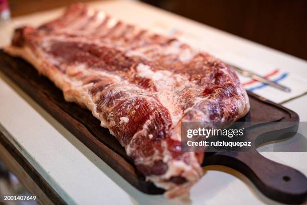 big piece of iberian bacon on a wooden board - adding salt stock pictures, royalty-free photos & images