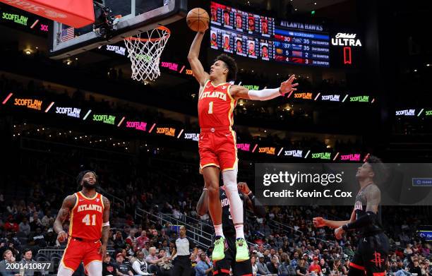 Jalen Johnson of the Atlanta Hawks dunks against Jeff Green and Jalen Green of the Houston Rockets during the first quarter at State Farm Arena on...