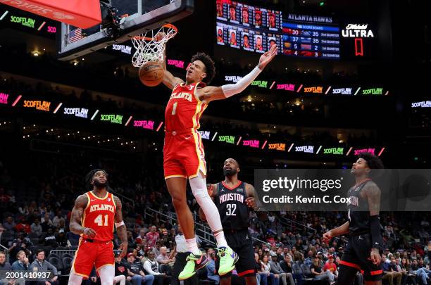 Jalen Johnson of the Atlanta Hawks dunks against Jeff Green and Jalen Green of the Houston Rockets during the first quarter at State Farm Arena on...