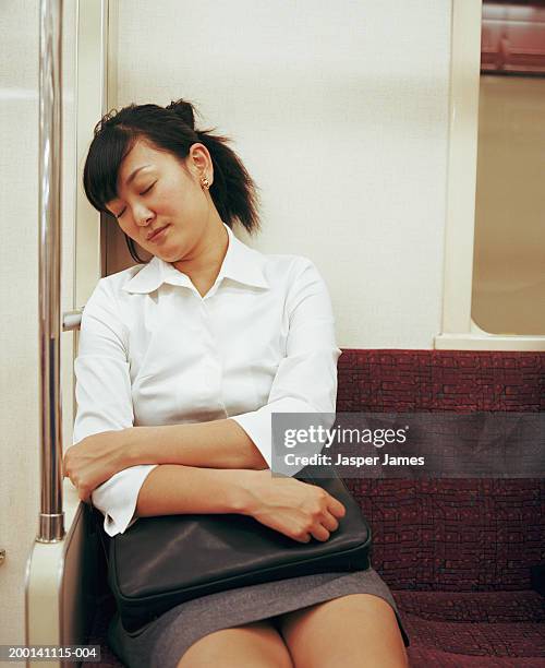 young businesswoman sleeping in subway train - matt japan stock-fotos und bilder