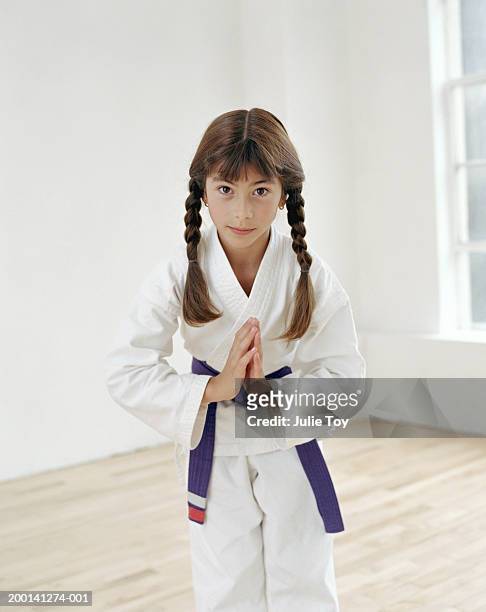 girl (7-9) in tae kwan do uniform bowing, portrait - karate girl stockfoto's en -beelden