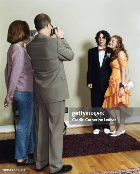 parents taking picture of teenage daughter (14-16) and prom date - prom photo imagens e fotografias de stock