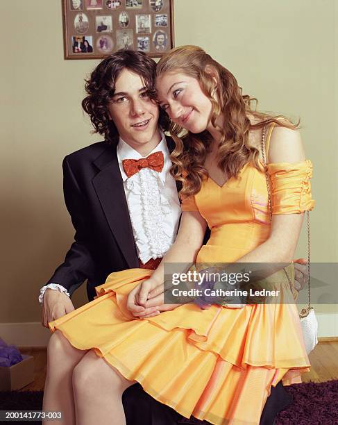 teenage couple (14-16) dressed for prom, girl sitting on boy's lap - prom dress stockfoto's en -beelden