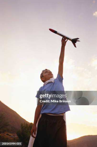 boy (10-12) playing with toy rocket, summer, low angle view - purple shirt mockup stock pictures, royalty-free photos & images