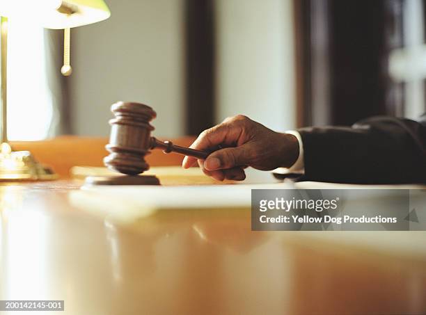 male judge striking gavel in courtroom, close-up - gerechtigheid stockfoto's en -beelden