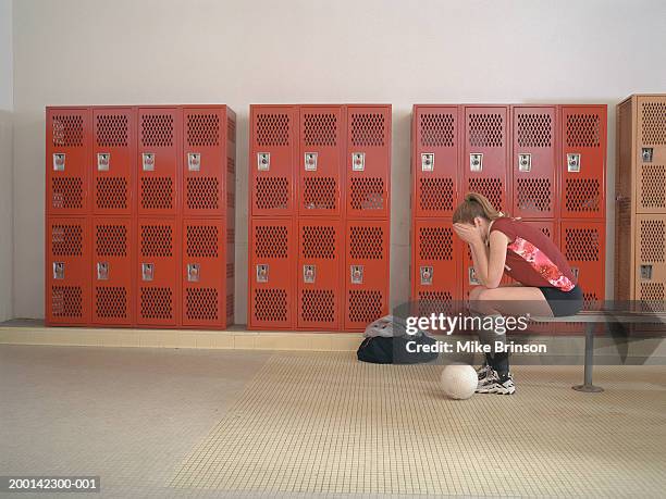 teenage girl (15-17) with hands on face in locker room, side view - girl locker room fotografías e imágenes de stock