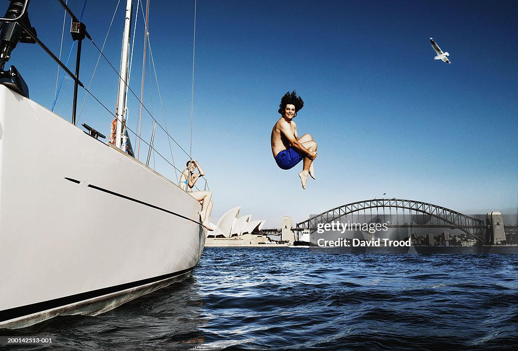 Australia, Sydney, young man jumping from boat in to harbour