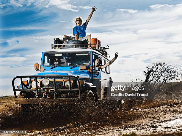 man on roof of 4x4, two men inside, shouting, arms raised - four wheel drive australia stock pictures, royalty-free photos & images