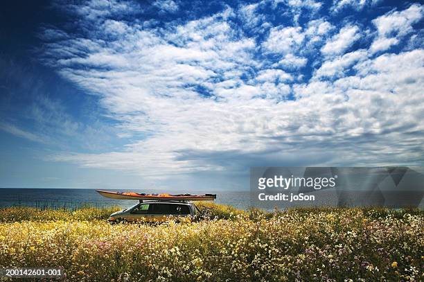 mini-van with kayak on roof and bicycle rack on back, side view - country road side stock pictures, royalty-free photos & images