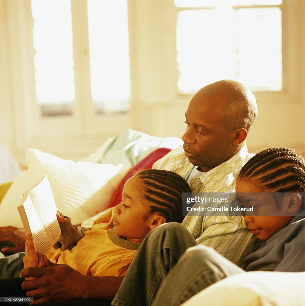 Father reading to twin sons (6-8)