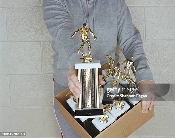 woman holding box of trophies, showing one, mid section, close-up - trophy wall stock pictures, royalty-free photos & images