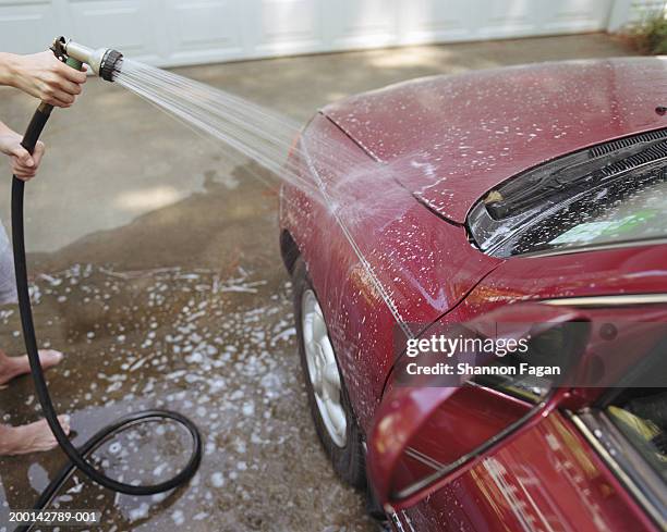 woman washing car - car in driveway stock-fotos und bilder