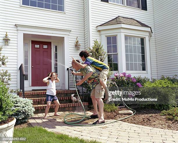 father and children (5-12) playing in front of home - spoilt children stock-fotos und bilder