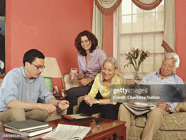 adults playing board game in living room, smiling - stoneplus4 stock pictures, royalty-free photos & images