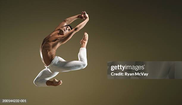 male ballet dancer in mid air pose - bailarín fotografías e imágenes de stock