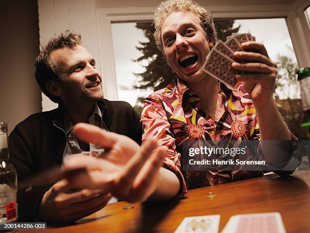 two men at table with playing cards, smiling - floral pattern suit stock pictures, royalty-free photos & images