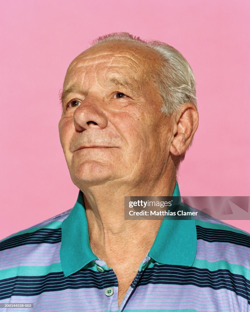 Senior man in striped shirt looking upward, close up