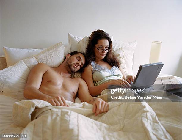 young man and mature woman in bed, woman using laptop - young man to bed photos et images de collection