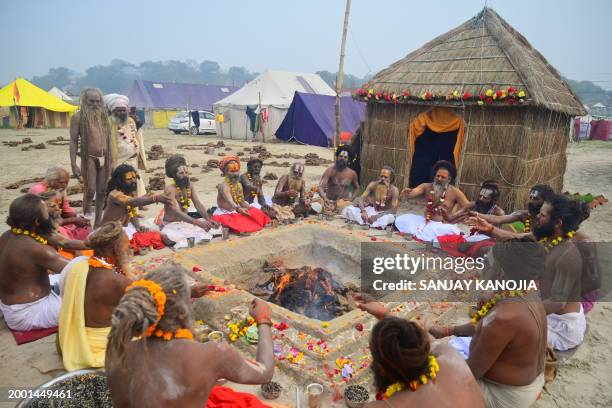 Sadhus or Hindu Holy men perform a ritual at the Sangam, the confluence of rivers Ganges, Yamuna, and mythical Saraswati on the auspicious day of...