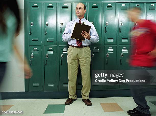 man in school hallway with clipboard - kontrolle stock-fotos und bilder