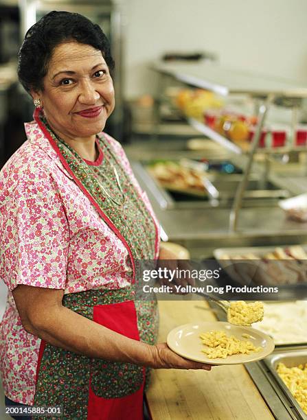 mature woman serving food in cafeteria, portrait - kantinenfrau stock-fotos und bilder