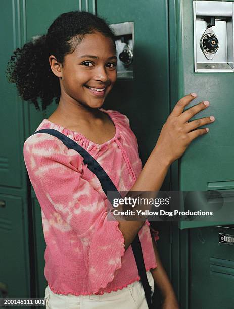 girl (12-14) holding locker door, smiling, portrait - 12 13 jaar stockfoto's en -beelden