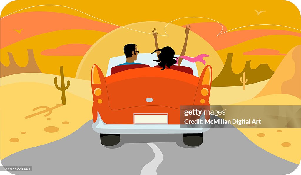 Couple in convertible driving into the sunset