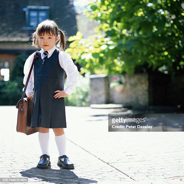 girl (3-5) wearing school uniform, holding bag, outdoors, portrait - ragazza scuola foto e immagini stock