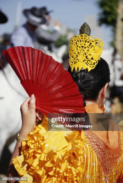 woman flamenco dancing, holding fan, rear view - feria de abril stock pictures, royalty-free photos & images