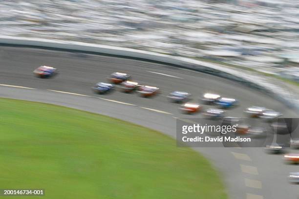 stock car race track, elevated view (blurred motion) - stock car racing stock-fotos und bilder