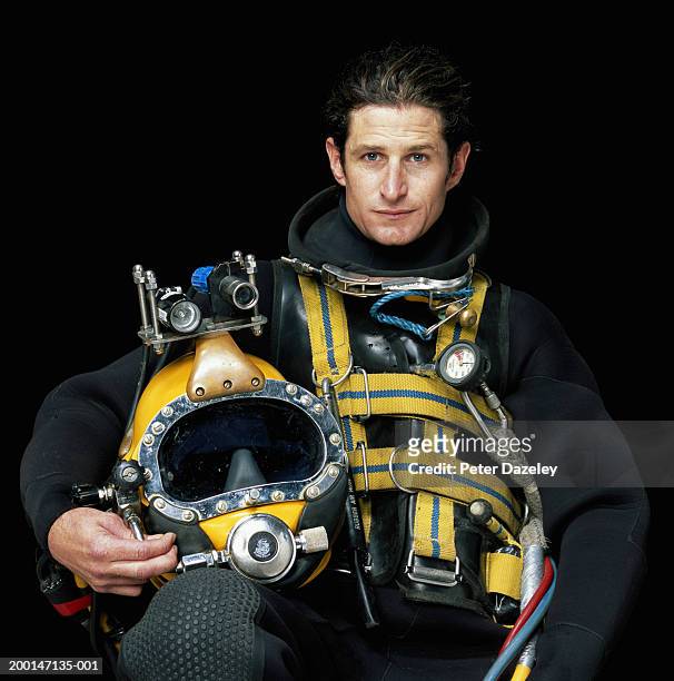 deep-sea diver holding helmet, portrait - ropa protectora deportiva fotografías e imágenes de stock