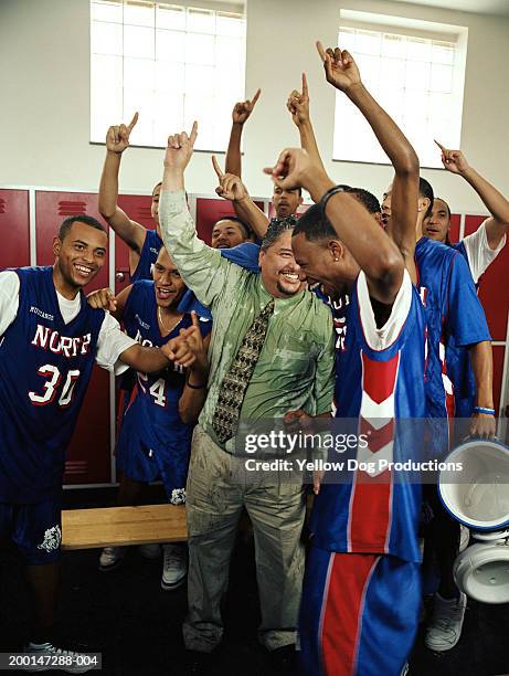 basketball players (16-18) in locker room celebrating with coach - sports team celebrating stock pictures, royalty-free photos & images