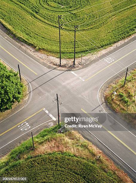 crossroads surrounded by farmland, aerial view - incrocio stradale foto e immagini stock