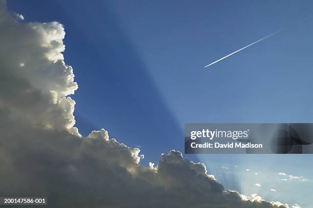 jet vapor trail and clouds across blue sky - every cloud has a silver lining stock pictures, royalty-free photos & images