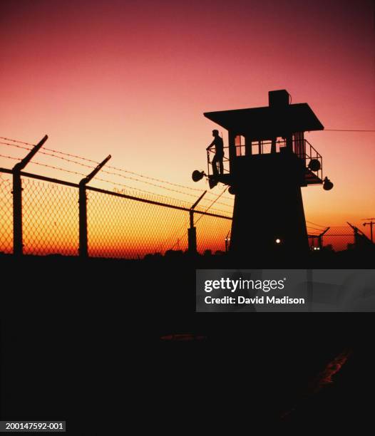 prison guard on duty in security tower at sunset, silhouette - prison guard stockfoto's en -beelden