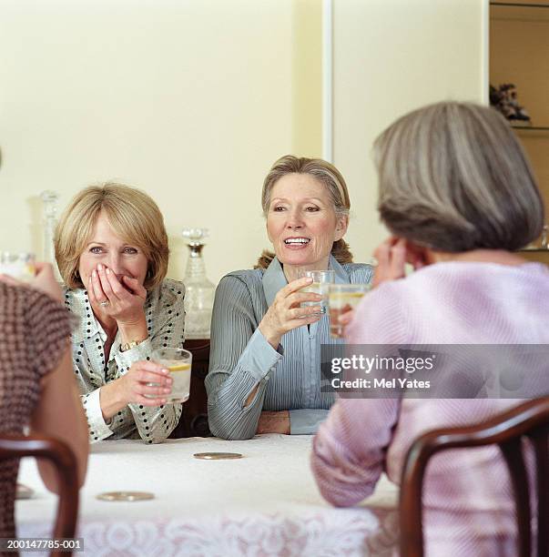 group of female friends drinking around table - solo donne mature foto e immagini stock