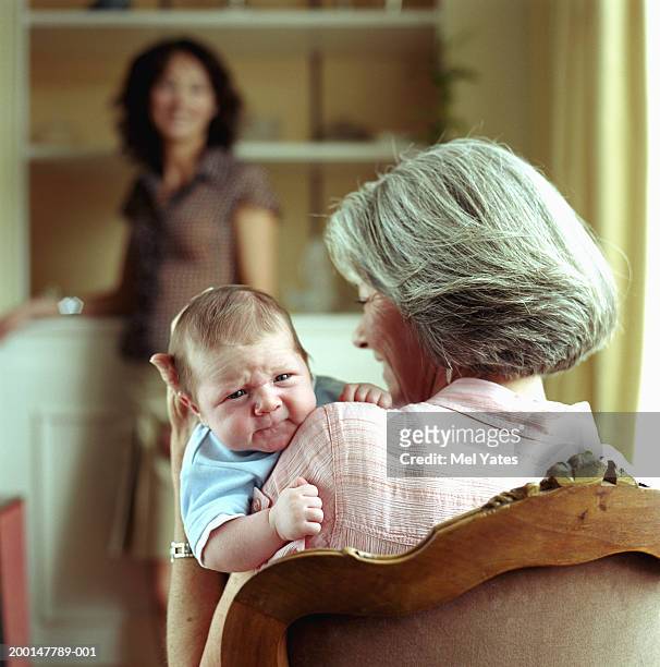 grandmother holding grandson (0-3 months), view over shoulder - multi generation family from behind stock pictures, royalty-free photos & images