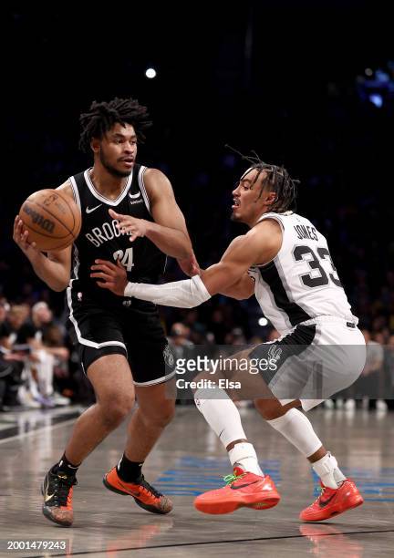 Cam Thomas of the Brooklyn Nets tries to get past Tre Jones of the San Antonio Spurs at Barclays Center on February 10, 2024 in the Brooklyn borough...